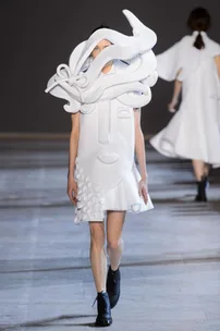 Model wearing Viktor & Rolf Haute Couture SS16 dress with 3D textured face design, walking on runway.