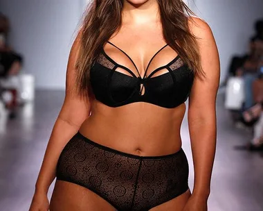 Ashley Graham walks the Addition Elle runway in lingerie.