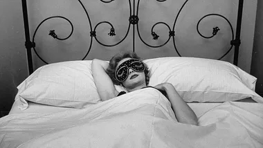 Woman in bed in sleeping mask.