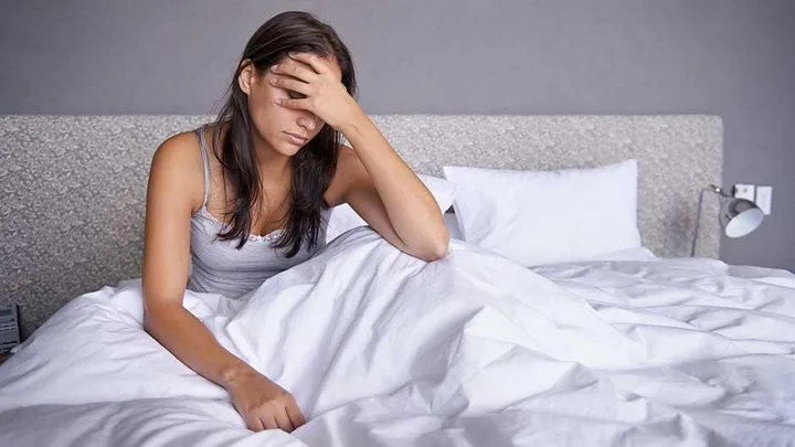 Woman in bed with migraine