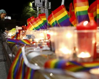 A woman lights a candle during a candlelight vigil for the victims of the Pulse Nightclub shooting in Orlando, Florida, at Oxford St on June 13, 2016 in Sydney, Australia.