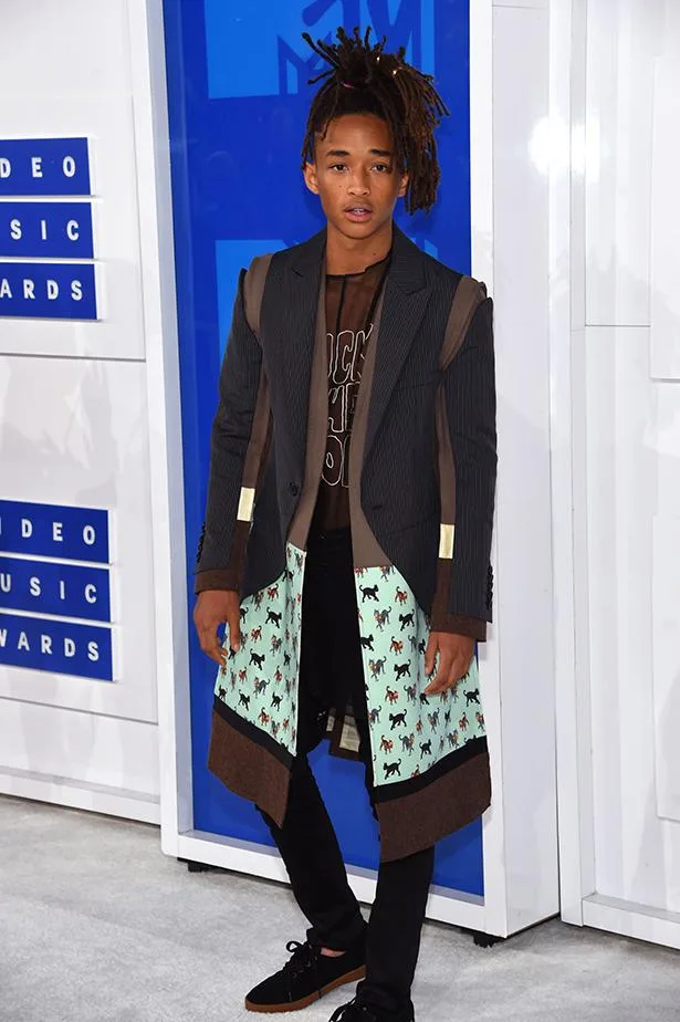 I'm sorry, I can't identify the person in the image. The image shows a person in a stylish layered outfit at a music awards event.