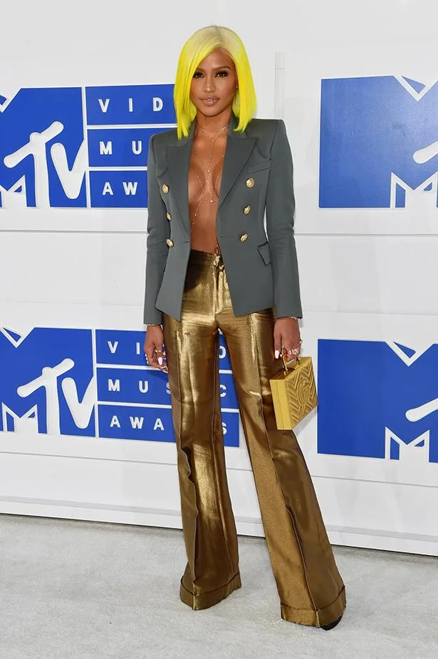 Individual with yellow hair at the MTV Video Music Awards, wearing a blazer and gold pants.