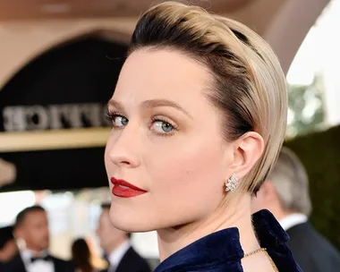 Evan Rachel Wood at the SAG Awards, with short blonde hair and red lipstick, wearing statement earrings and a blue outfit.