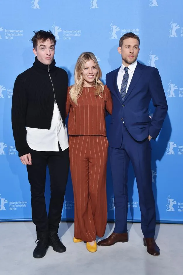 Three people posing on a red carpet at the Berlin Film Festival.