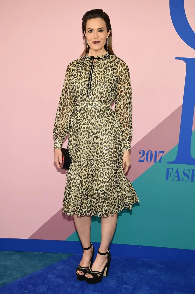 "Person in a leopard print dress poses on a blue carpet against a pink and teal backdrop with '2017 Fashion' text."