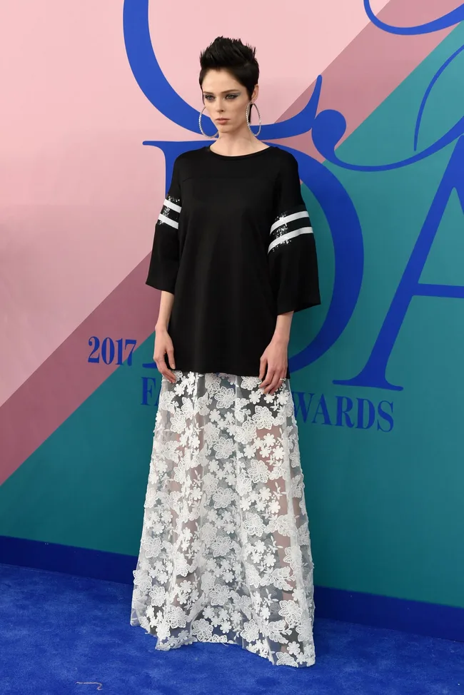 Model in a black top with striped sleeves and a long, sheer floral skirt at the 2017 Fashion Awards.