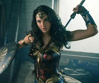 Gal Gadot as Wonder Woman, holding a sword and shield, in a battle-ready pose from the movie "Wonder Woman."