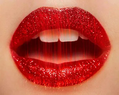 Close-up of glossy, glittery red lips slightly parted, showcasing a vibrant and bold makeup look.