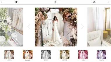 Bride in white lace gown taking a mirror selfie in floral-decorated bridal boutique.