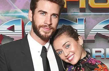 Miley Cyrus and Liam Hemsworth smiling and posing together at the "Thor: Ragnarok" premiere.