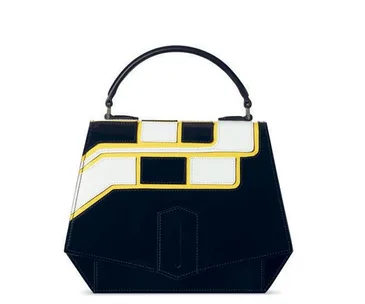 Geometric black leather handbag with white and yellow accents; top handle design.