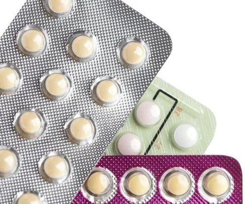 Blister packs of contraceptive pills in various colors arranged diagonally.