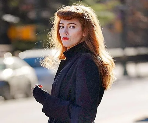 Blake Lively as Stephanie Patrick, wearing a wig with bangs, in a scene from "The Rhythm Section," standing outdoors in a dark coat.