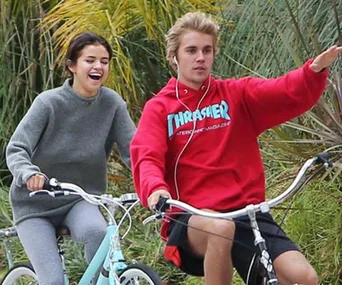 Selena Gomez and Justin Bieber riding bicycles, smiling and enjoying outdoors, 2018.