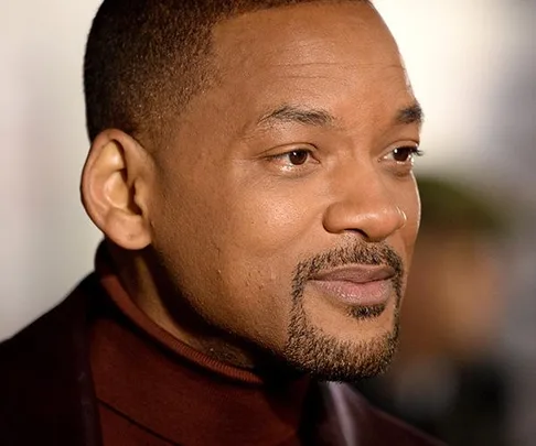 A close-up portrait of Will Smith wearing a maroon turtleneck and dark jacket.