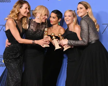 The cast of "Big Little Lies," including Reese Witherspoon, posing with Golden Globe awards at an event.