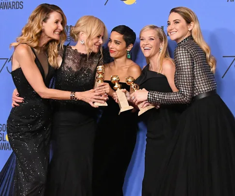 The cast of "Big Little Lies," including Reese Witherspoon, posing with Golden Globe awards at an event.