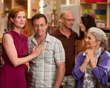 Cynthia Nixon, as Miranda Hobbes in "Sex and the City," stands with others in a school setting.