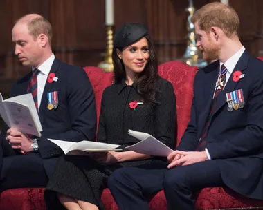 Three individuals seated at ANZAC service; one appears to be dozing, while two others engage in conversation, all holding booklets.