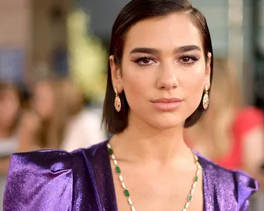 Dua Lipa in a purple dress on the red carpet at the 2018 Billboard Music Awards.