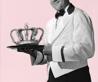 A waiter in formal attire holds a tray with a royal crown on it against a pink background.