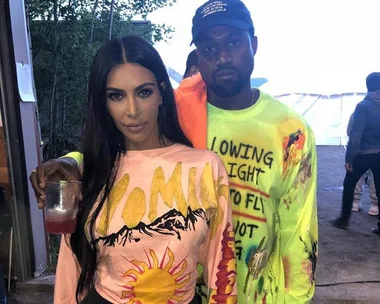 A man and woman wearing colorful shirts, the man wearing a cap, posing closely together outdoors.