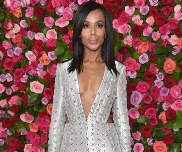 A woman in a silver, deep V-neck dress with floral background at the 2018 Tony Awards red carpet.