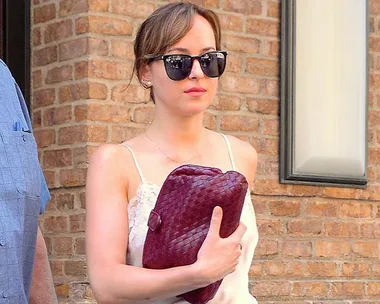 Dakota Johnson walks through the airport with sunglasses on