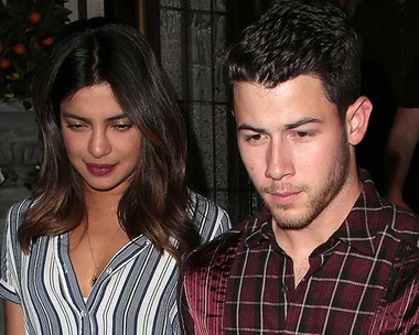 Priyanka Chopra and Nick Jonas walking together outdoors, both looking down.