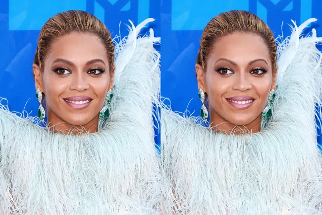 Woman in a feathered outfit with emerald earrings smiles against a blue background.