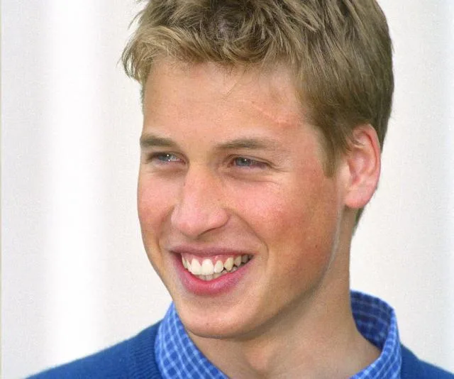 A young man with a smile and a faint scar on his forehead, wearing a blue shirt and sweater, from prince-william-harry-potter-scar-18402.