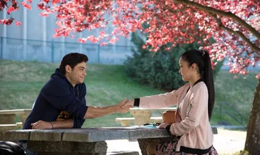 Lara Jean and Peter shake hands across a table under a tree with pink blossoms in "To All the Boys I've Loved Before."