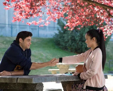 Lara Jean and Peter shake hands across a table under a tree with pink blossoms in "To All the Boys I've Loved Before."