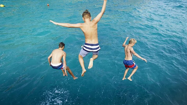 Boys jumping off a cliff.