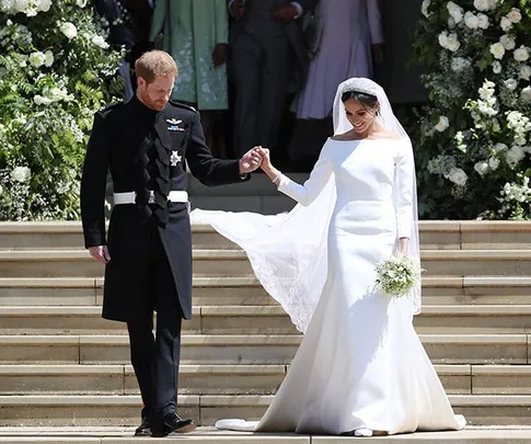 Prince Harry and Meghan Markle exiting church on their wedding day, with Meghan in a white wedding dress.