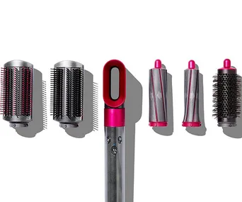 Dyson Airwrap styler and its five attachments including two barrels, two smoothing brushes, and a round volumizing brush.