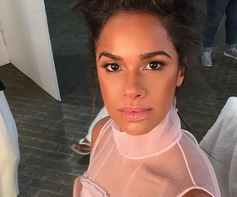 Ballet dancer Misty Copeland looks at the camera backstage, wearing a light pink sheer top with a high neckline.