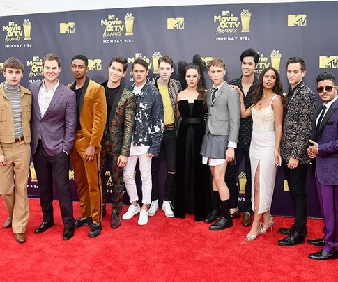 Cast of "13 Reasons Why" on the red carpet at the MTV Movie & TV Awards, posing together and smiling for the cameras.