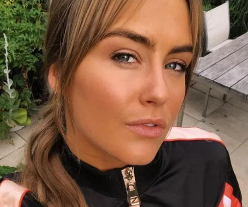 A close-up of Steph Claire Smith outdoors, wearing a black jacket with her hair tied back.