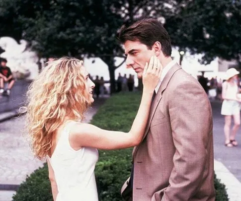 Carrie Bradshaw touching Mr. Big's face in a park from "Sex and the City".