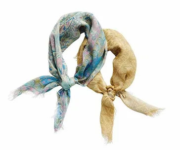 Two patterned scarves, one blue with paisley design and one beige with a subtle pattern, tied together in a knot against a white background.