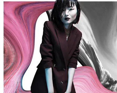 Fashion model in dark blazer against an abstract pink and gray swirling background for VAMFF 2019.