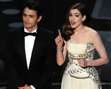 James Franco and Anne Hathaway hosting the Oscars, dressed formally on stage.