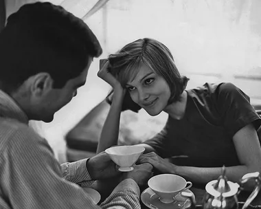 A couple enjoying a romantic coffee date, sharing smiles and holding hands across the table.