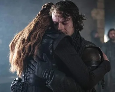 Sansa and Theon embrace in an emotional reunion scene indoors from Game of Thrones.