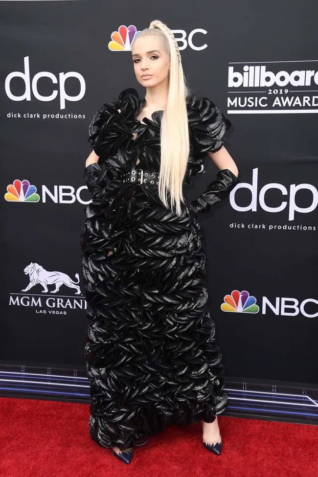 Person in a black textured dress with long blonde hair on the red carpet at the Billboard Music Awards 2019.