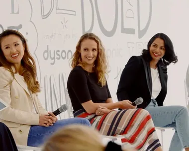 Three women sitting on a panel, holding microphones, against a backdrop with the word "Dyson" visible.