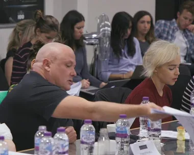 Actors reading scripts around a table for a Game of Thrones Season 8 table read session.