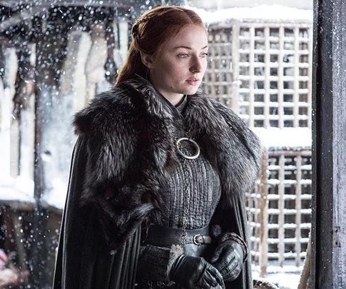 Sansa Stark stands in the snow wearing a fur cloak in "Game of Thrones".